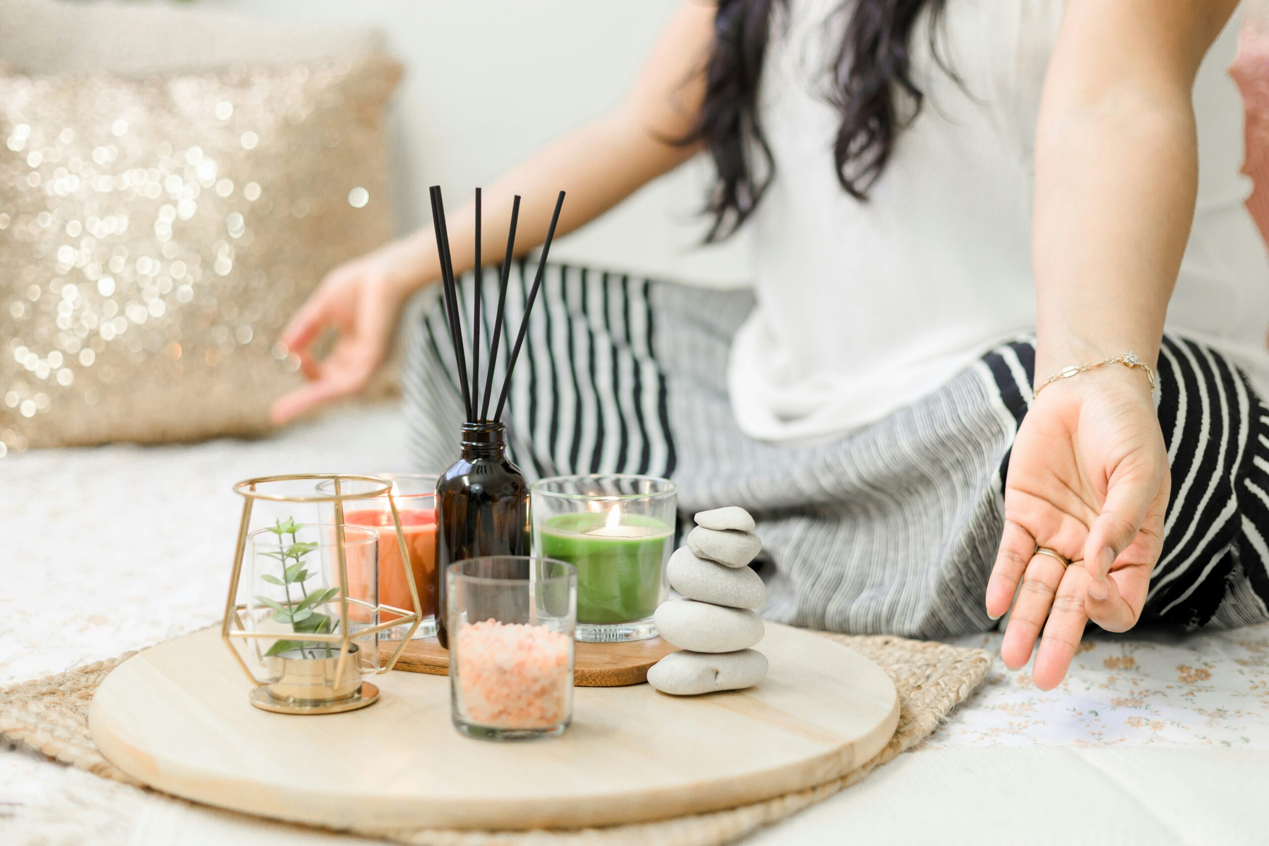 Woman using calming techniques to deal with menopause panic attacks - meditation, green tea and calming oils.