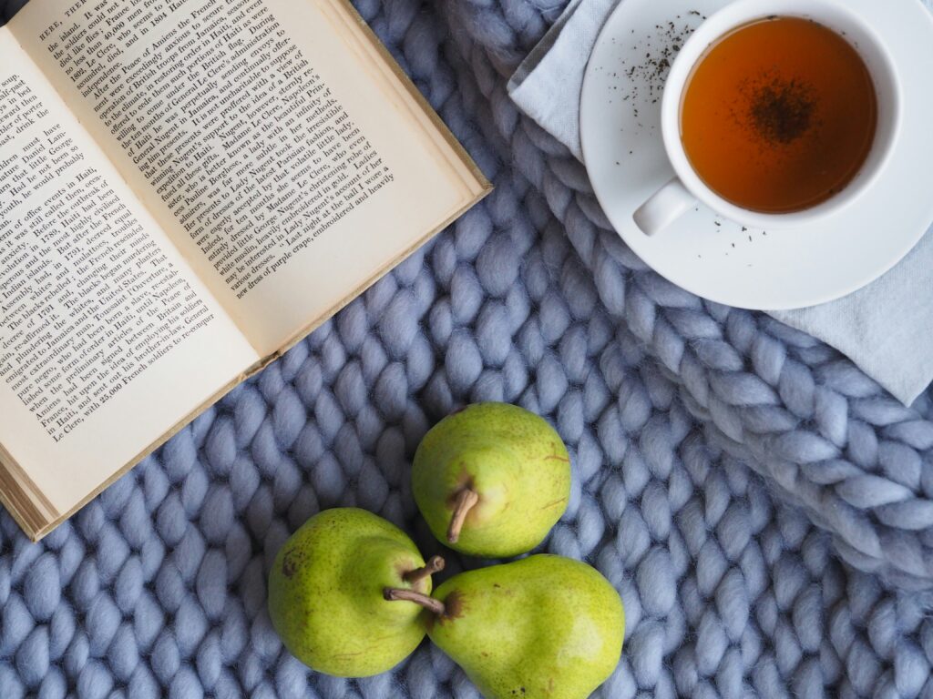 A chunky blanket, pears, a cup of tea and a book to celebrate self care and tackle perimenopause brain fog.