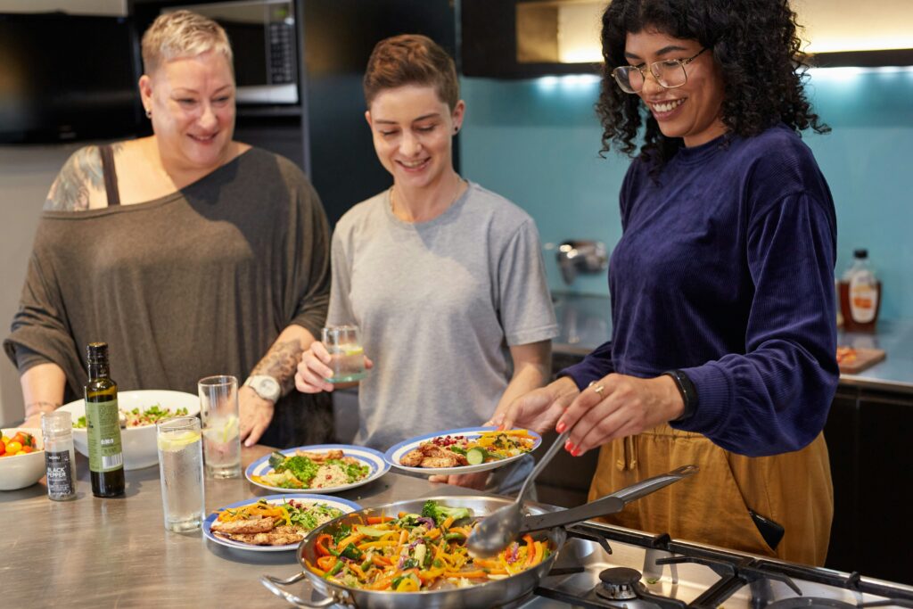 A group of women cooking a vegetable based lunch to improve perimenopause fatigue