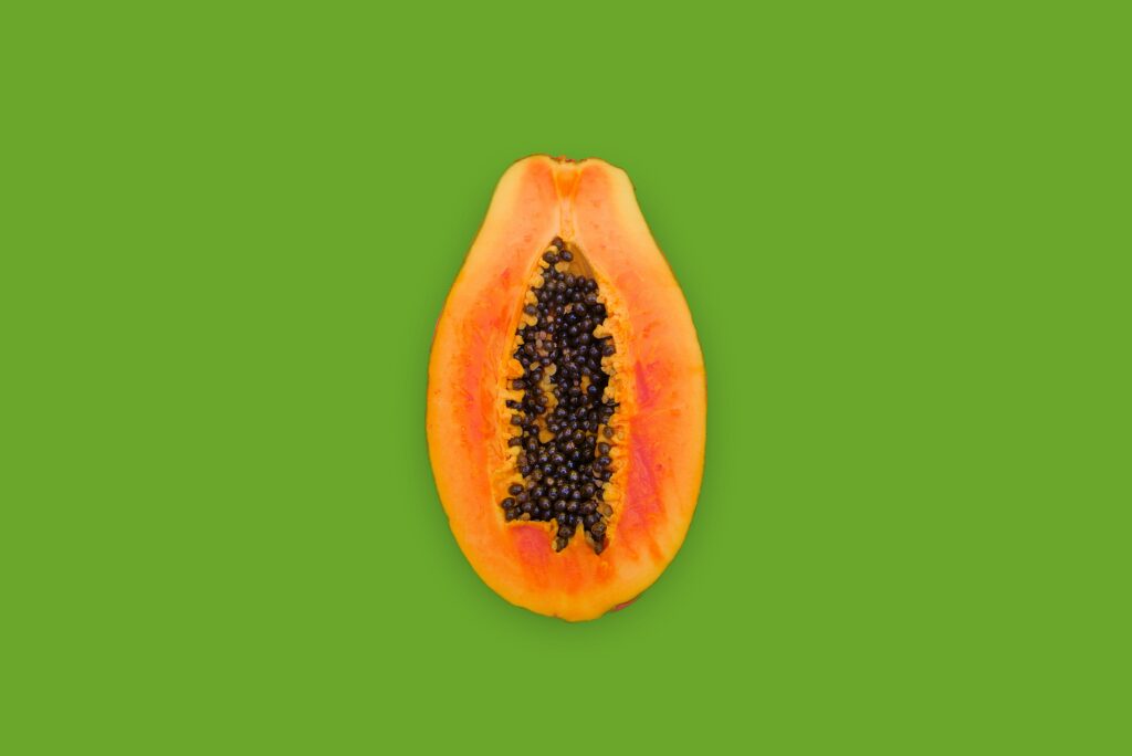 An open papaya on a green background to represent vaginal dryness and how this impacts libido and the menopause.