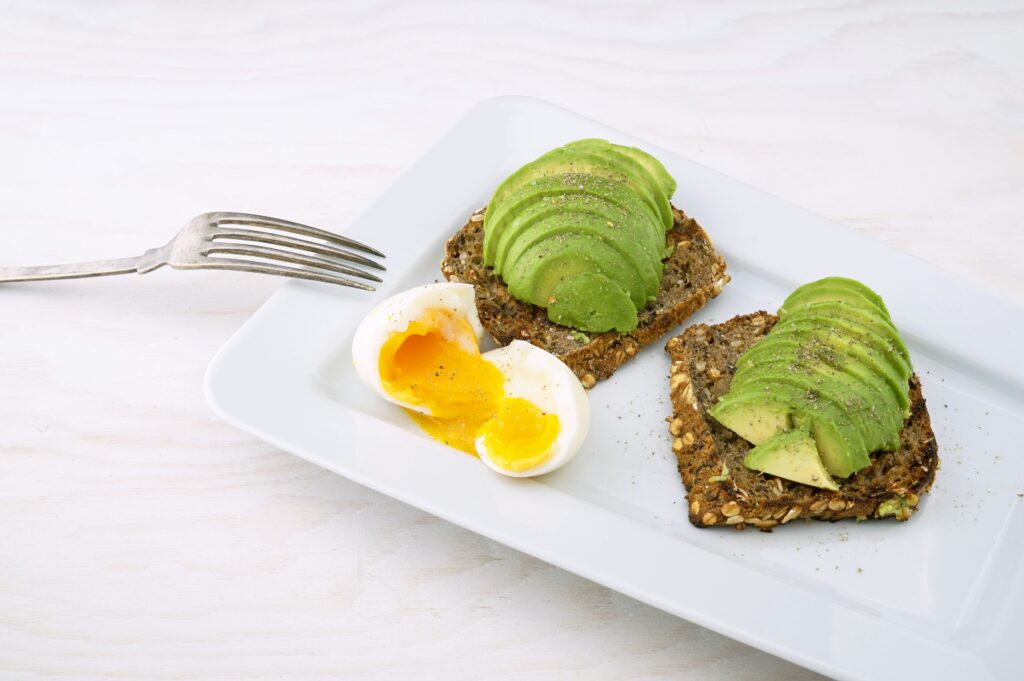 A breakfast plate of avocados, poached eggs and wholegrain toast as they are great foods for skin.