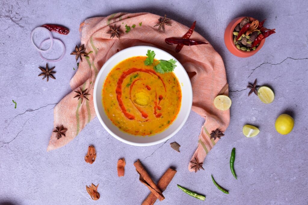 A bowl of bell pepper soup, combining some of the best foods for skin - cinnamon, red and yellow bell peppers, lemon and chillies. 