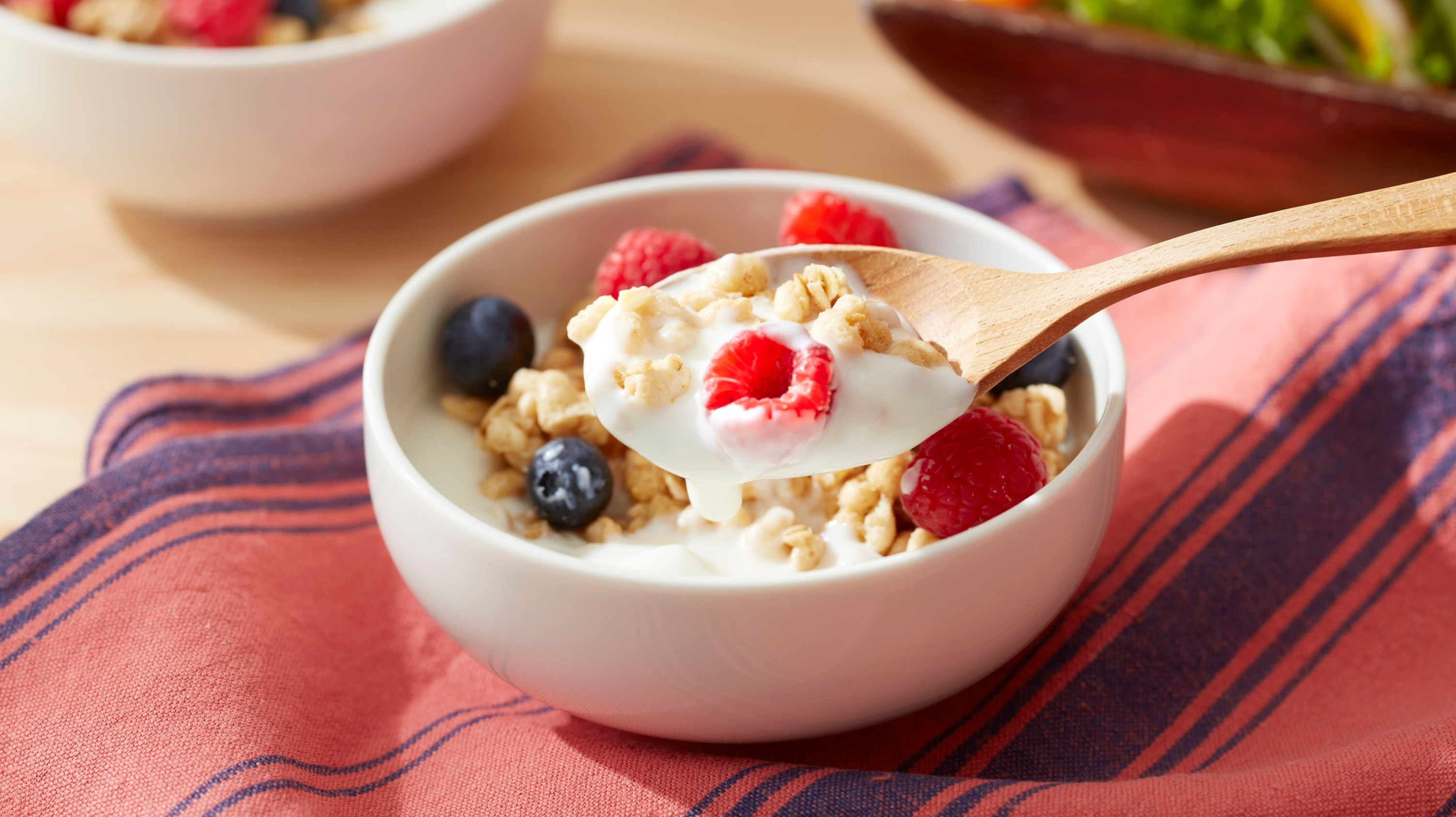 A bowl of breakfast yoghurt with oats, raspberries and blueberries - some of the best foods for perimenopause 