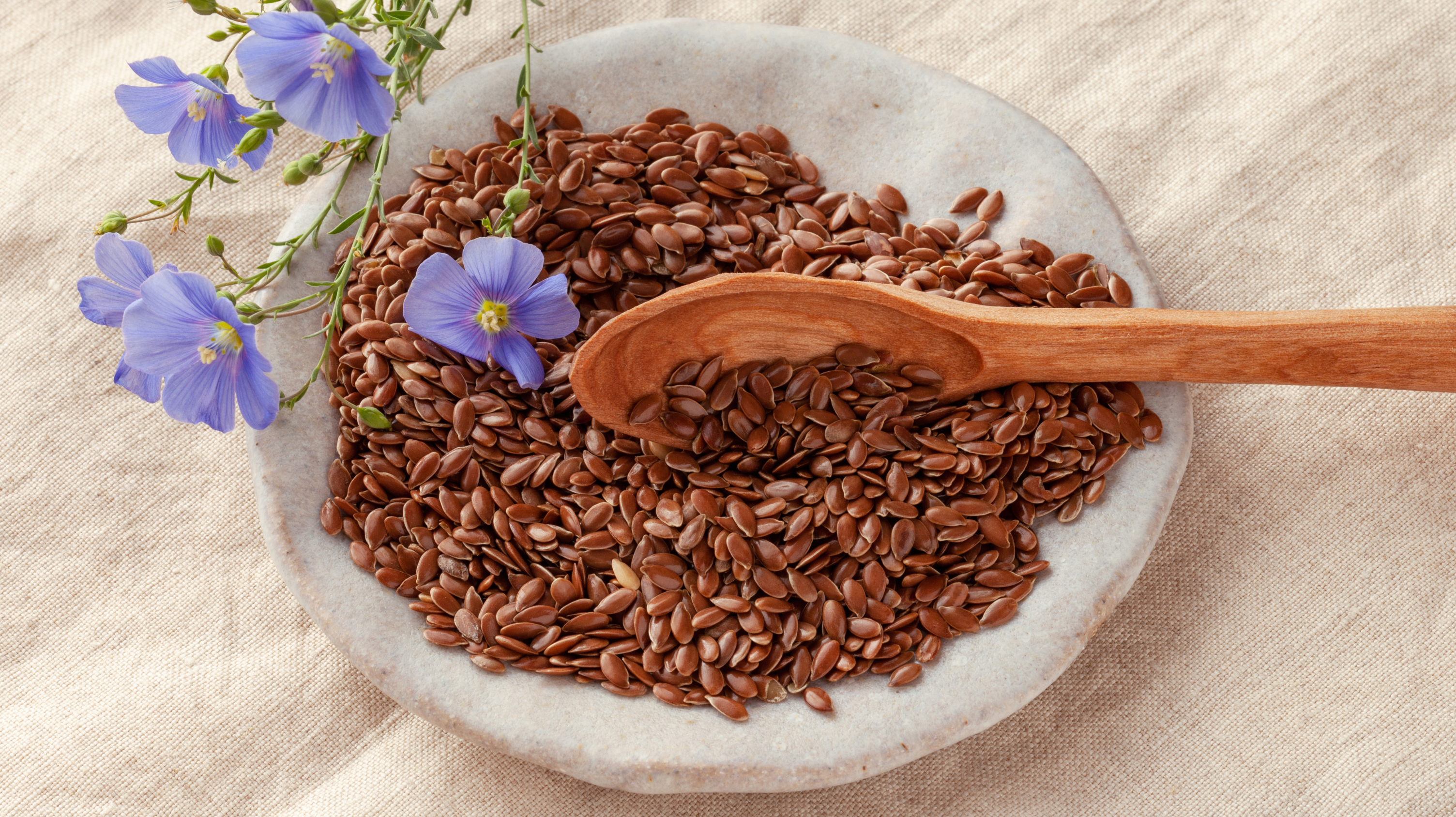 Full of magnesium, this bowl of flaxseeds are great foods for perimenopause. Garnished with purple edible flowers. 