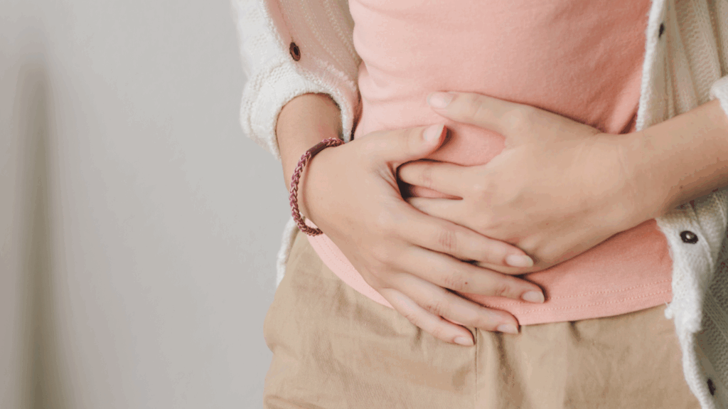 Woman holding her stomach, suffering from menopause bloating