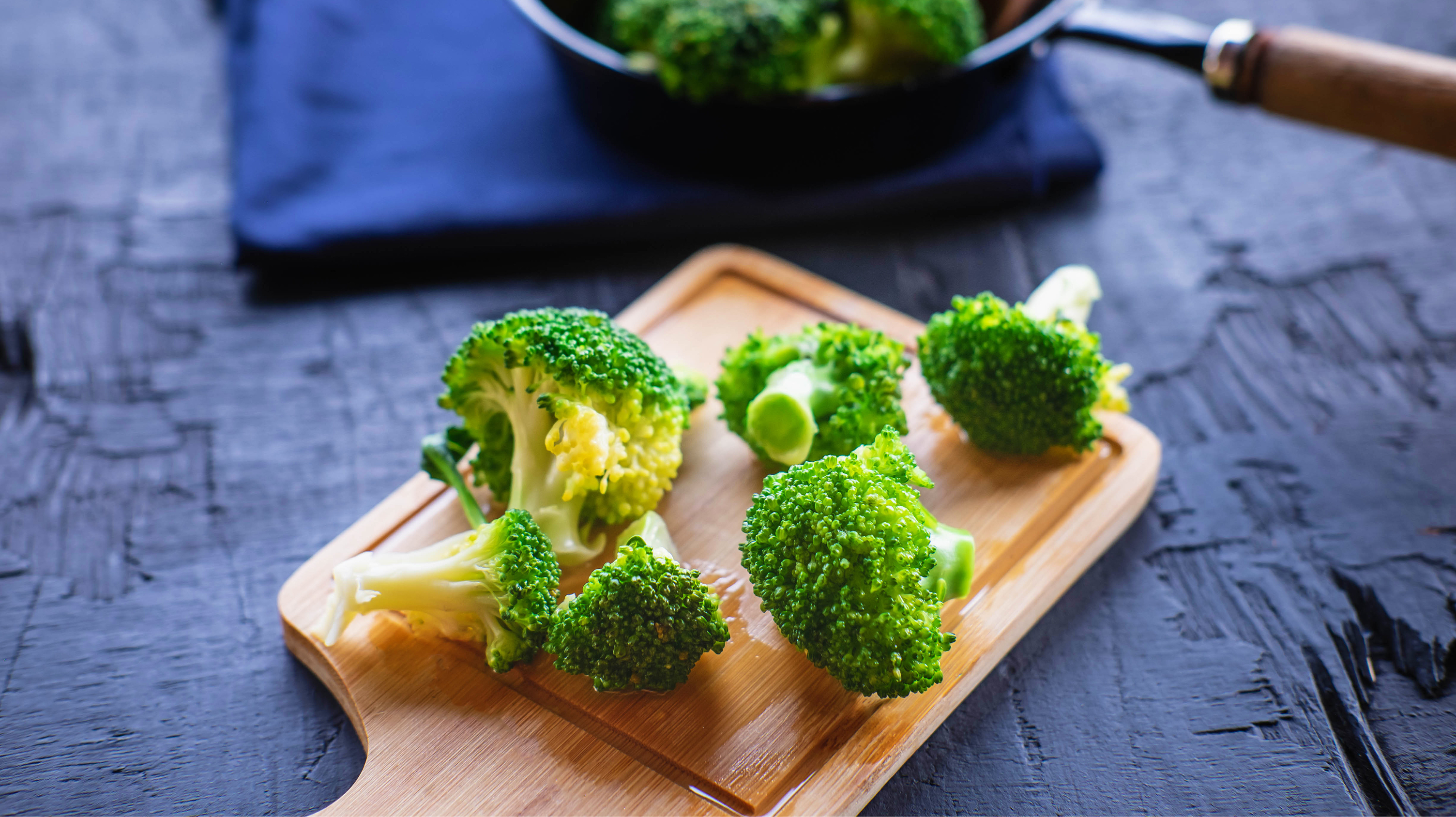 A chopping board with broccoli florets on it - prepped to fight perimenopause and headaches