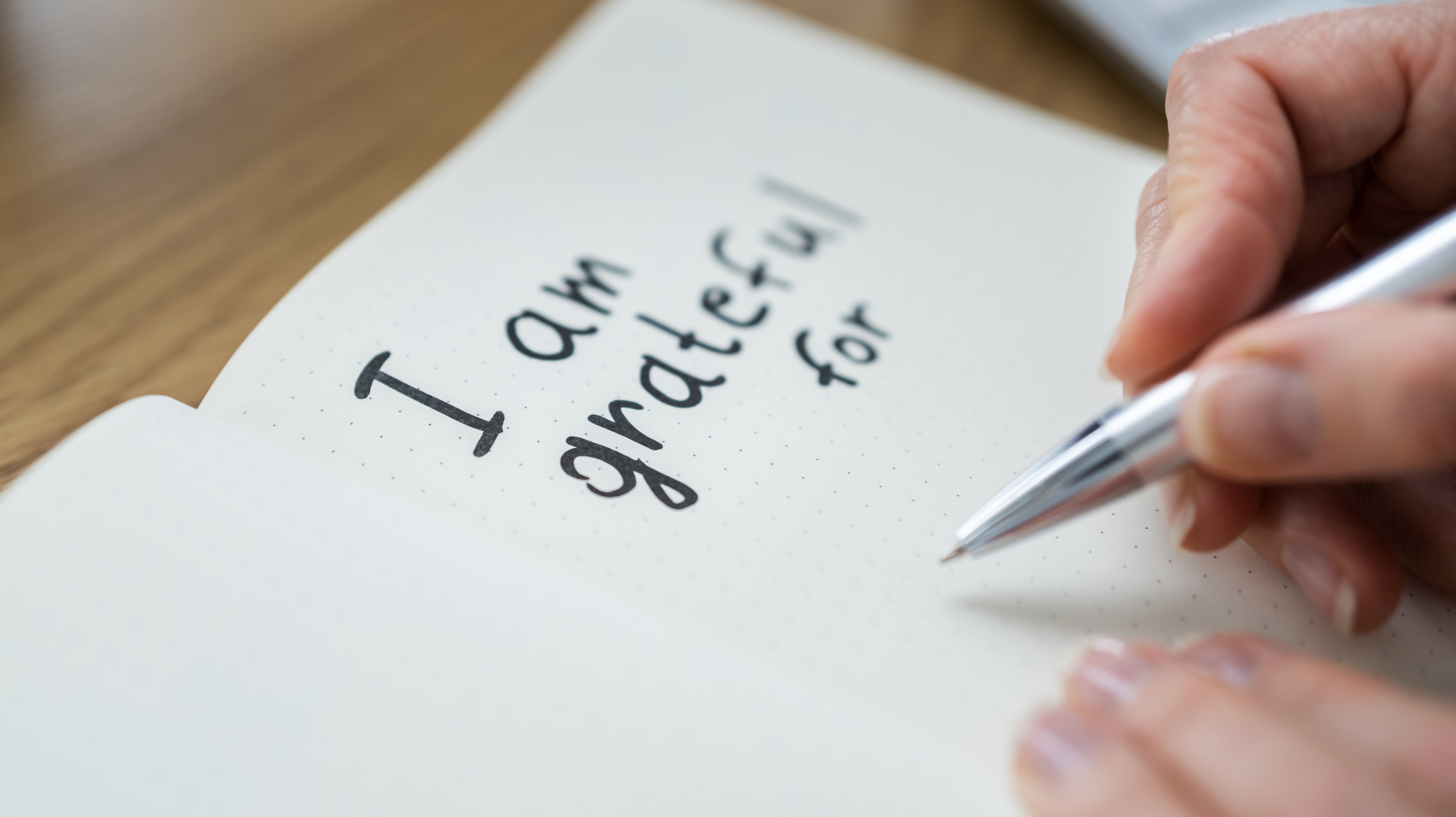 Open notebook with “I am grateful for” - woman journalling to tackle menopause and depression as a coping technique