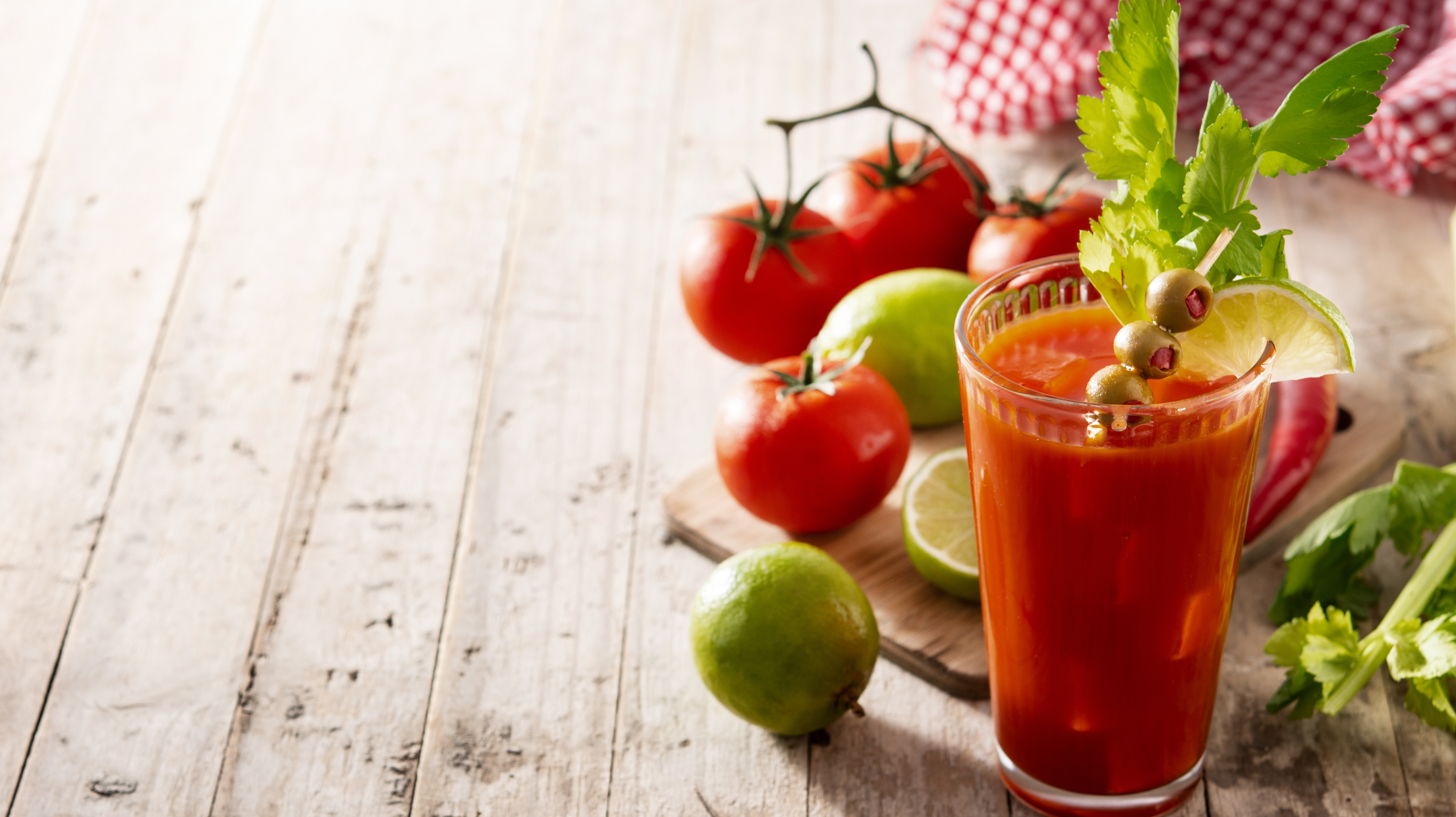 One of the most menopause friendly mocktail drinks - an alcohol free bloody Mary with cherry tomatoes and limes in the background.
