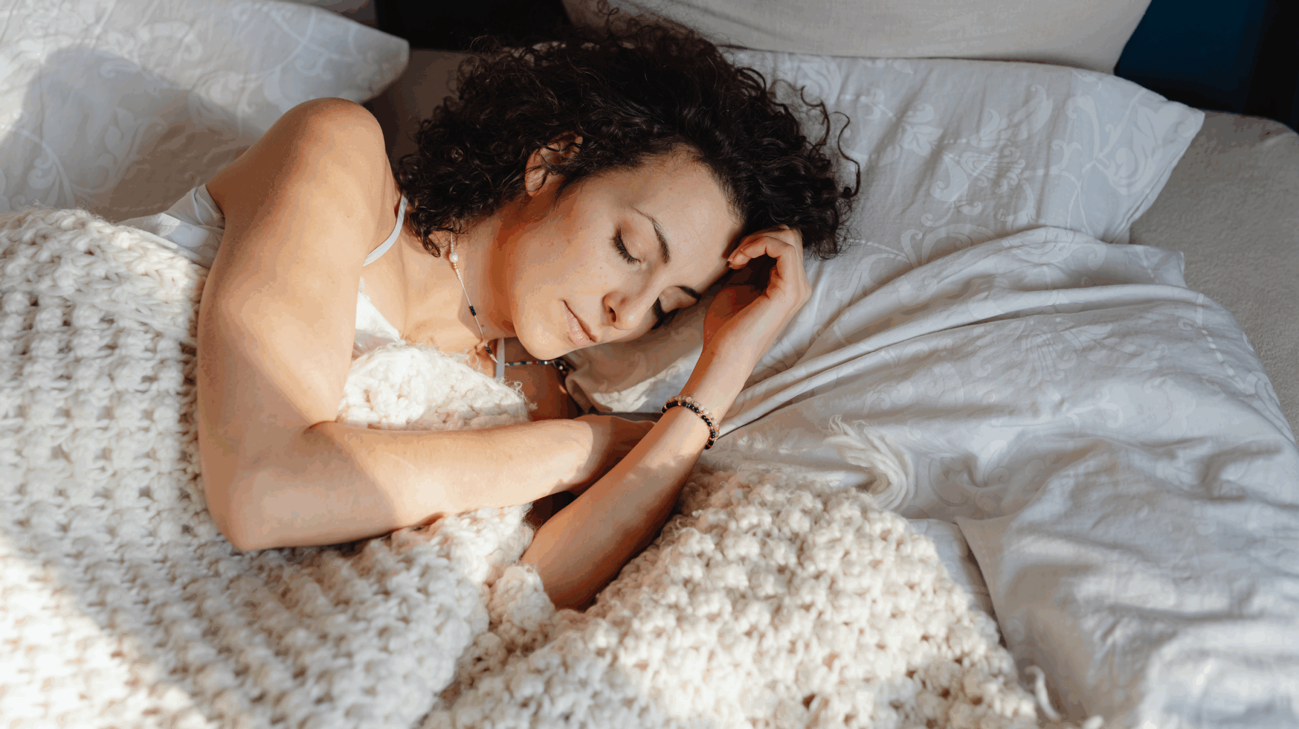 Woman in bed having better sleep as improved sleep and less disruption are signs perimenopause is ending